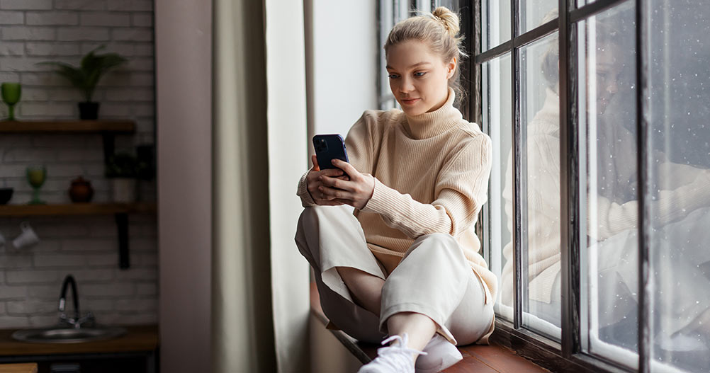 Mulher olhando para o celular - Jornada de Compra para Instituições de Ensino