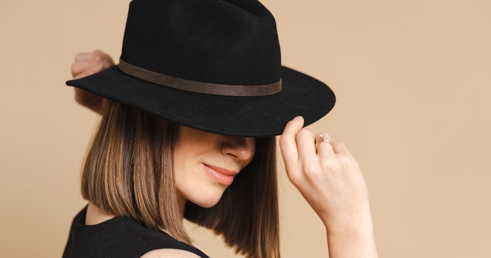 mulher branca segurando chapéu preto - Black Hat SEO