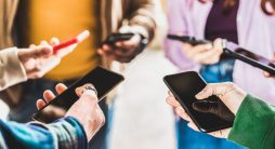 Vista de perto das mãos das pessoas usando dados em smartphones móveis - Fake influencers