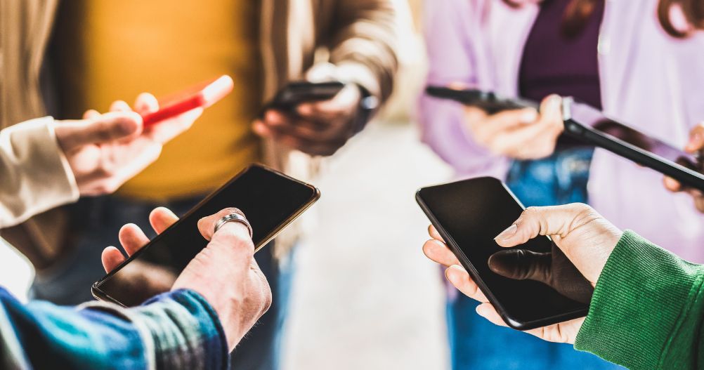 Vista de perto das mãos das pessoas usando dados em smartphones móveis - Fake influencers