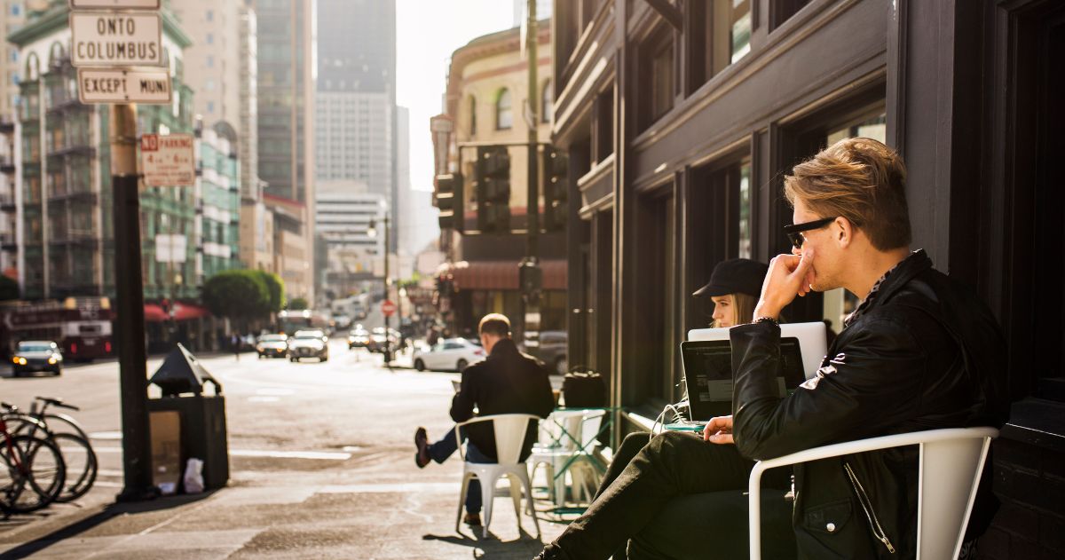 homem sentado em uma mesa de um café de rua - SEO para negócios locais