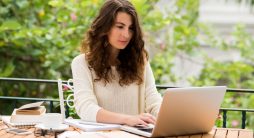 Copy para Vendas - escritora do sexo feminino em ambiente externo com seu laptop e folhas de papel